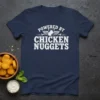 T-shirt with white distressed text "POWERED BY CHICKEN NUGGETS" and a graphic of wings and a nugget