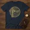 Navy blue t-shirt with gold text "Pray On It. Pray Over It. Pray Through It." around a Celtic cross design