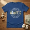 Promoted to Auntie Est. 2026 circular design with gold glitter text and baby footprint graphics on a navy blue t-shirt