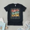 Promoted To Big Sister est. 2025 text with baby feet graphic on a black t-shirt, framed by floral elements