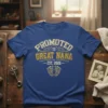 Promoted to Great Nana Est. 2026 text and baby footprints graphic on a blue t-shirt