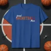 Proud Basketball Mom text design with distressed orange "BASKETBALL" and white "proud" and "Mom" on a blue t-shirt