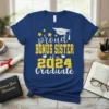 Proud Bonus Sister of a 2024 Graduate text with graduation cap and stars graphic on a blue t-shirt