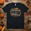 Pumpkin Kisses & Harvest Wishes text design with pumpkins, leaves, and lights on a black t-shirt