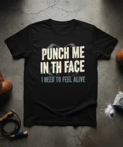 Black t-shirt with bold white text "PUNCH ME IN TH FACE" and smaller blue text "I NEED TO FEEL ALIVE"