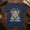 T-shirt with "READ BOOKS BE KIND STAY WEIRD" text and a sugar skull reading a book, surrounded by celestial and