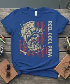 Reel Cool Papa text and bass fish jumping with American flag background on a blue t-shirt