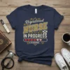 Registered Nurse In Progress Loading text design with hearts and progress bar graphic on a navy t-shirt