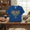 Blue t-shirt with distressed gold text "RELAX I'M HERE" and an anchor graphic with waves