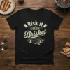 Black t-shirt with "Risk it FOR THE Brisket" text, cleavers, and a smoking brisket graphic