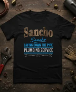 Black t-shirt with "Sancho Sancho LAYING DOWN THE PIPE PLUMBING SERVICE" text and wrench graphic