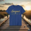 Blue t-shirt with "Savannah GEORGIA" in gold script and block letters, featuring a small tree emblem