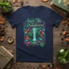 Save The Rainforest text graphic with vibrant jungle scene, waterfall, and two parrots on a navy blue t-shirt