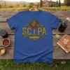 SCIPA text in distressed gold font with circular corn and chili pepper graphic on a royal blue t-shirt
