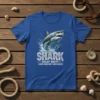 Shark Great White Carcharodon Carcharias text with a leaping shark graphic on a blue t-shirt