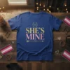 She's Mine lesbian couple pride t-shirt design with gold and pink glitter text and two figures holding hands