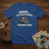 Blue t-shirt with "SHHH... I'M WATCHING WRESTLING" text and graphic of two wrestlers in a ring
