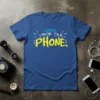 Blue t-shirt with yellow and white text reading "shhh, i'm on The PHONE." in a playful font