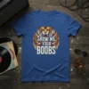 Show Me Your Boobs text with a roaring tiger and wings graphic on a blue t-shirt