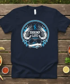 Navy blue t-shirt with "Shrimp Life" text, two shrimp graphics, aviator sunglasses, and blue wave design in a circle