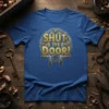 Blue t-shirt with "SHUT THE DOOR!" text in gold, surrounded by a steampunk-inspired mechanical gear design