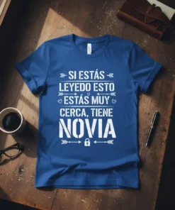 Spanish humorous quote "Si Estás Leyendo Esto, Estás Muy Cerca, Tiene Novia" on a blue t-shirt design with white typography