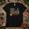 Black t-shirt with "SIX SEVEN" in festive Christmas font, candy cane style, surrounded by holiday lights, bells, and a Christmas