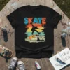 Black t-shirt featuring the word SKATE in a retro, graffiti-style font above a silhouette of a skateboarder mid-air over a