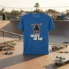 Blue t-shirt with black silhouette of a skateboarder mid-air and "SKATE OR DIE" text in white graffiti style
