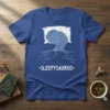 Blue t-shirt with a drawing of a sleeping dinosaur and the text "-SLEEPYSAURUS-"