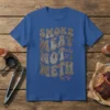 T-shirt with "Smoke Meat Not Meth" text in distressed metal font, featuring BBQ grill tools and chemical symbols