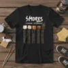 Black t-shirt displaying "Smores Cooking Techniques" with illustrations of marshmallows in different stages of roasting, each with a humorous caption