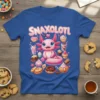 Cute pink axolotl character with the word SNAXOLOTI surrounded by cupcakes, donuts, and cookies on a blue t-shirt