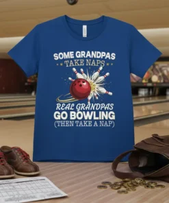 Blue t-shirt with white text: "SOME GRANDPAS TAKE NAPS REAL GRANDPAS GO BOWLING (THEN TAKE A NAP)" and bowling ball