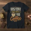 Some Heroes Wear Capes Some Heroes Make Your Coffee text with coffee cup graphic on a dark t-shirt