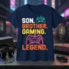 SON. BROTHER. GAMING. LEGEND. text with neon game controllers on a navy t-shirt