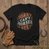 Sorry Can't Horses Bye text design on a black t-shirt, featuring retro orange and white lettering with decorative swirls and