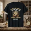 Sorry I Am Cranky I'm Going Through My Terrible Seventies Right Now quote on a black t-shirt featuring a grumpy