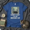 Black cat sitting by window with text "SORRY I CAN'T -I'M AN- INDOOR CAT" on a blue t-shirt