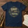 Navy blue t-shirt with "SORRY I TOOTED" text and a golden trombone graphic inside an ornate circular frame