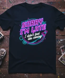 "Sorry I'm Late I Didn't Feel Like Coming" quote on a black t-shirt, featuring neon pink and blue typography, gears