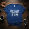 White text on blue t-shirt reading "SORRY I'M LATE I DIDN'T WANT TO COME" with doodle clocks and lines
