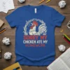 Graphic tee with "Sorry My Chicken Ate My Homework" text and a distressed rooster illustration, framed by wheat stalks
