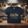 Gold glitter text "Sous Chef" with kitchen knife and whisk graphic on a navy blue t-shirt