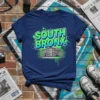 South Bronx NYC urban district graphic tee with bold green and blue text and building illustration