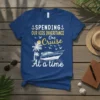 Spending Our Kids Inheritance One Cruise At a Time text design on a navy t-shirt, featuring a boat, palm trees