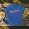 Spread Cheeks. NOT HATE. text design on a royal blue t-shirt, featuring cream and pink typography