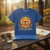 Stay Golden Golden Retriever wearing sunglasses graphic on blue t-shirt, with sunburst and laurel leaves