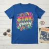 Blue t-shirt with "STAY groovy" text in colorful psychedelic font, surrounded by flowers and peace signs