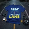Blue t-shirt with white and yellow text "STAY IN YOUR LANE" and a graphic of a road stretching into the